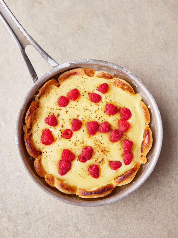A pan-baked lemon cheesecake decorated with fresh raspberries